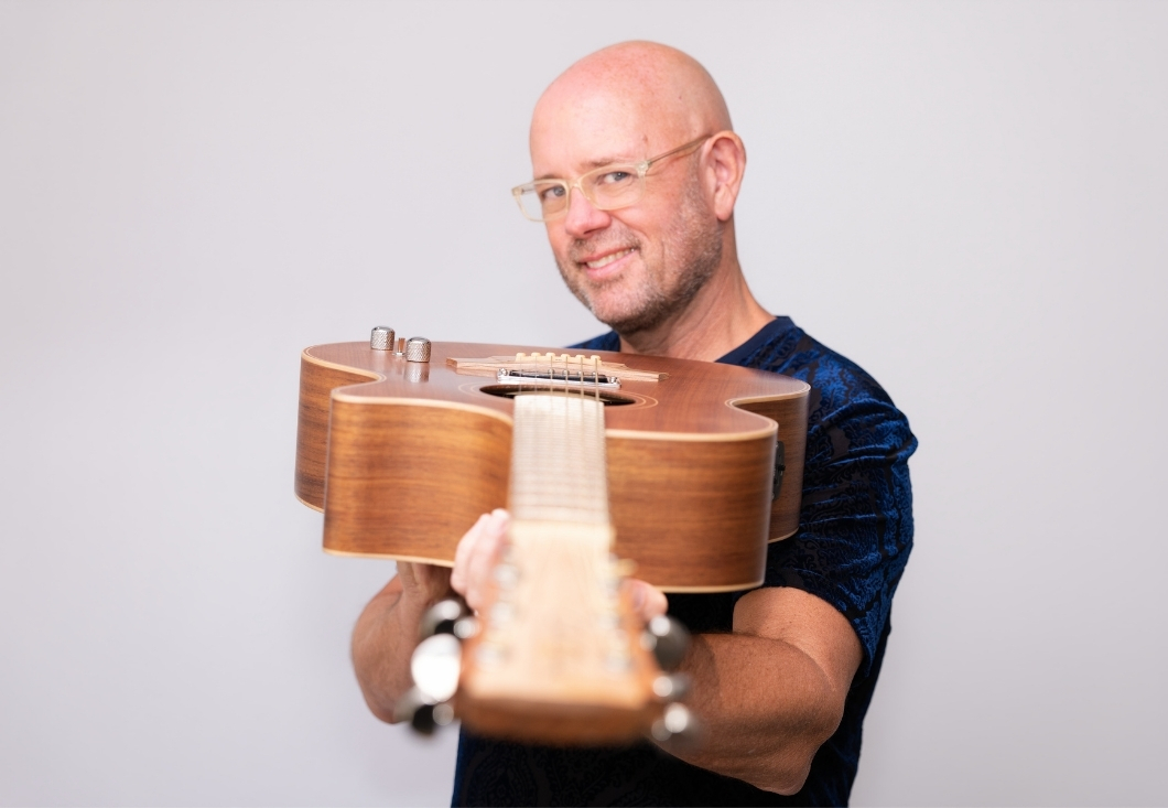 Bob Sima pointing his guitar